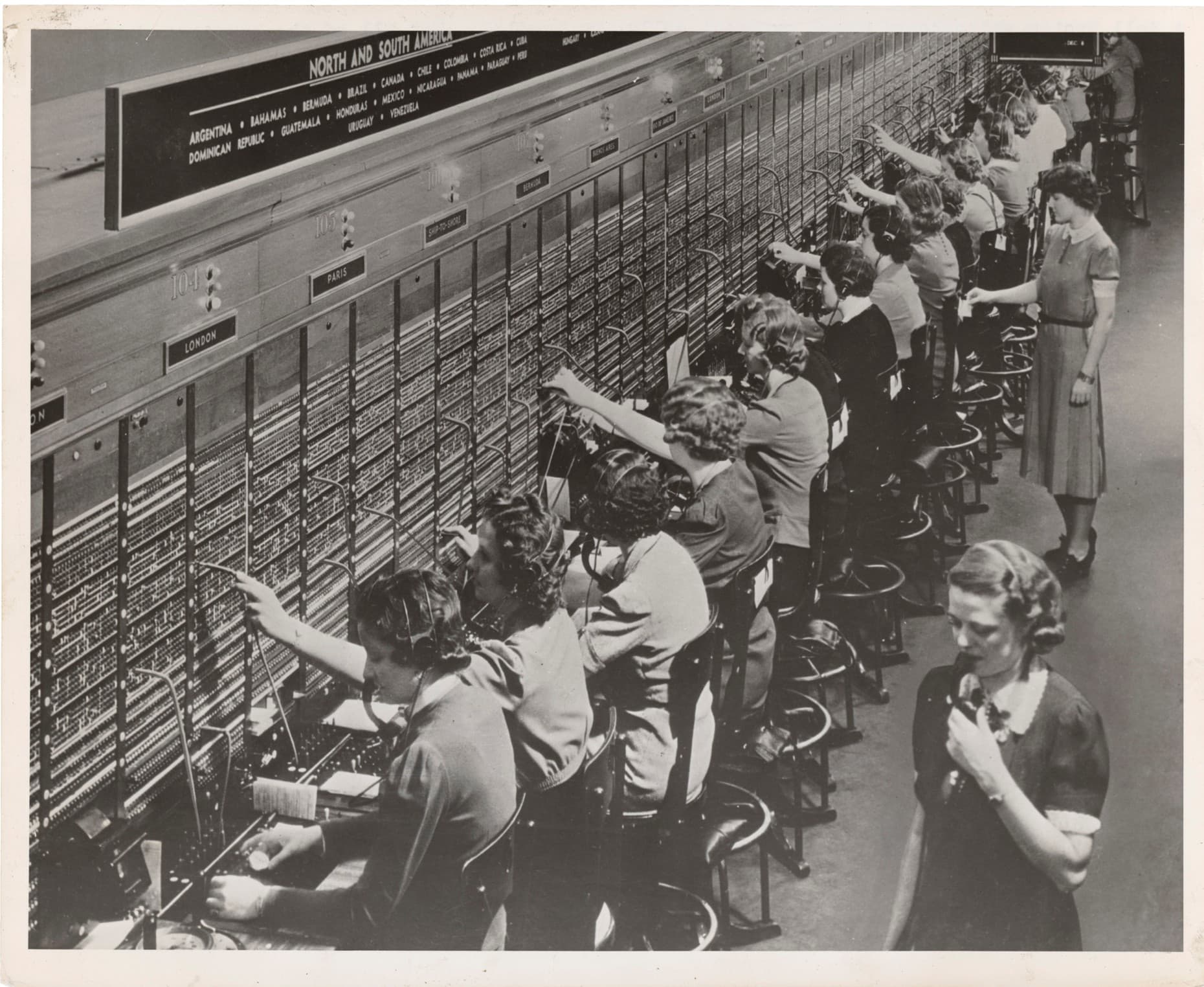 row of ladies sitting at an old fashioned switchboard wall row of ladies sitting at an old fashioned switchboard wall